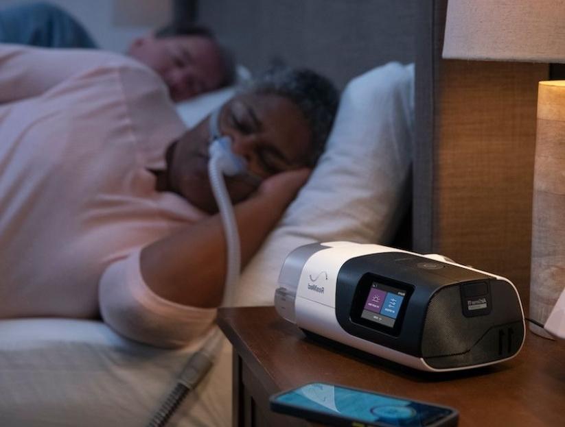 A person sleeping with a CPAP machine.