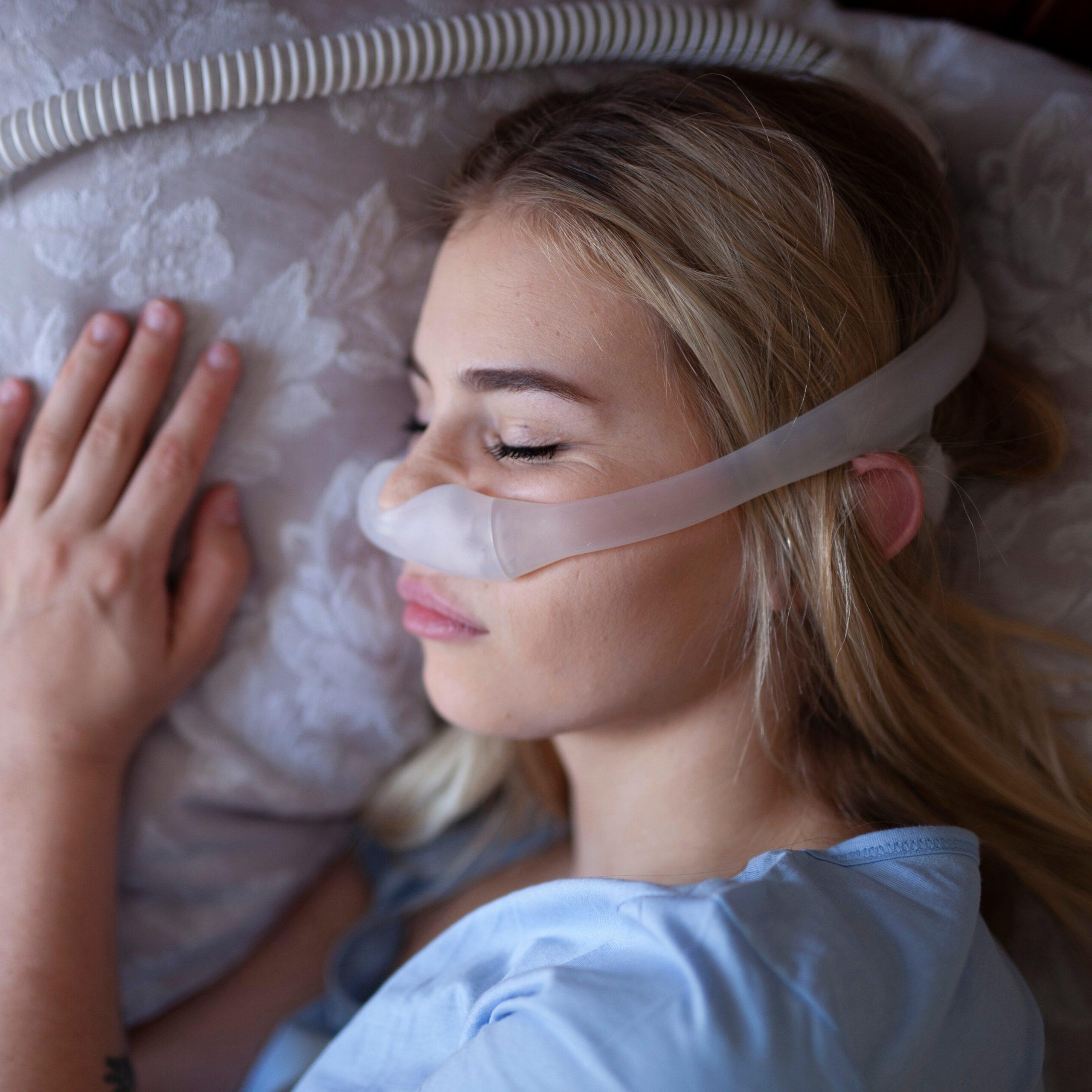 A woman sleeping with her CPAP mask on.